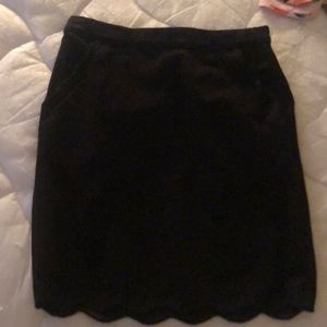 Black mini skirt size XS. Swoop bottom hem with pockets. Stretchy waist band